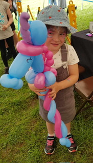 girl holding purple unicorn balloon
